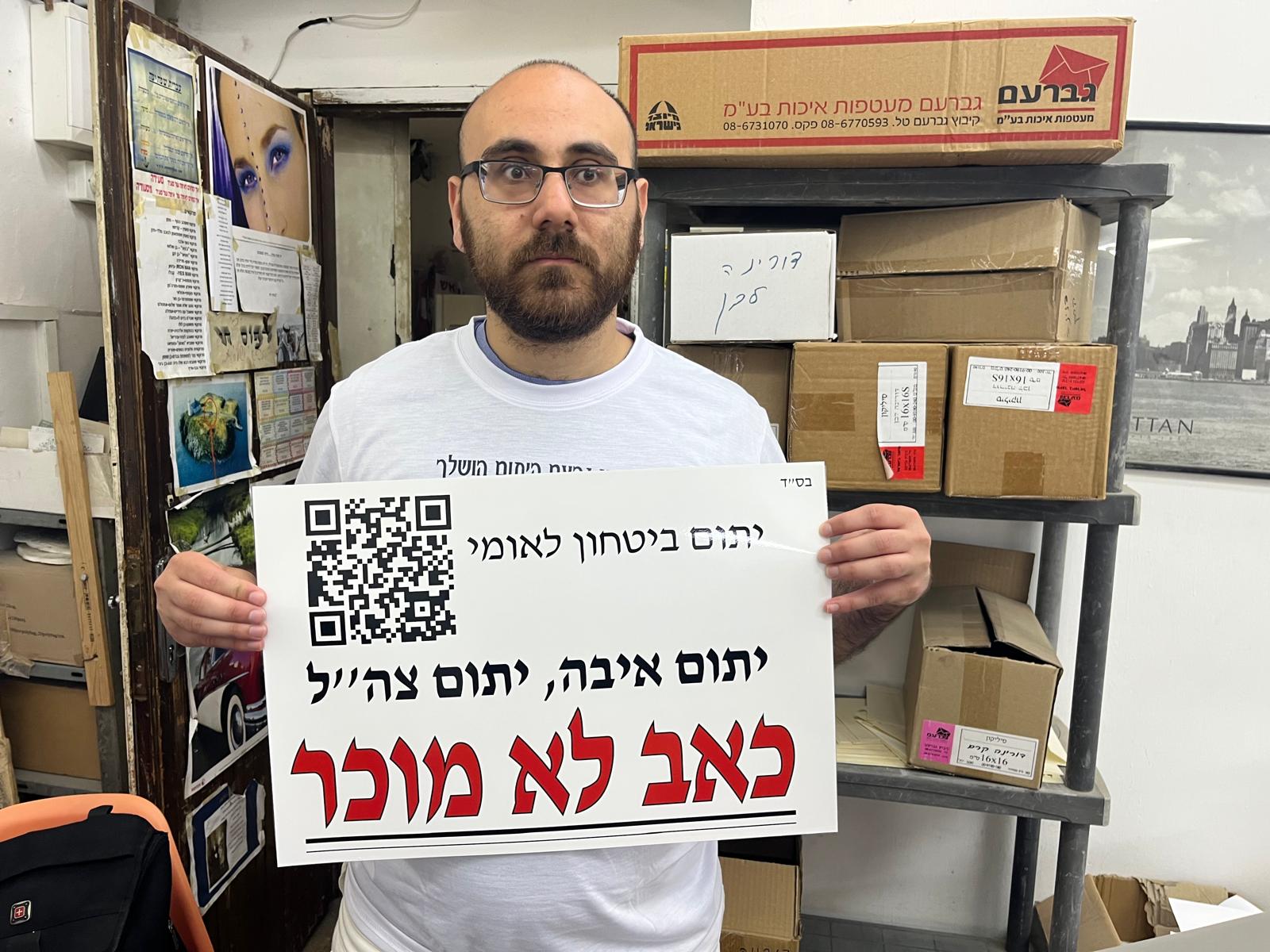 אסיף מחזיק שלט 'כאב לא מוכר'